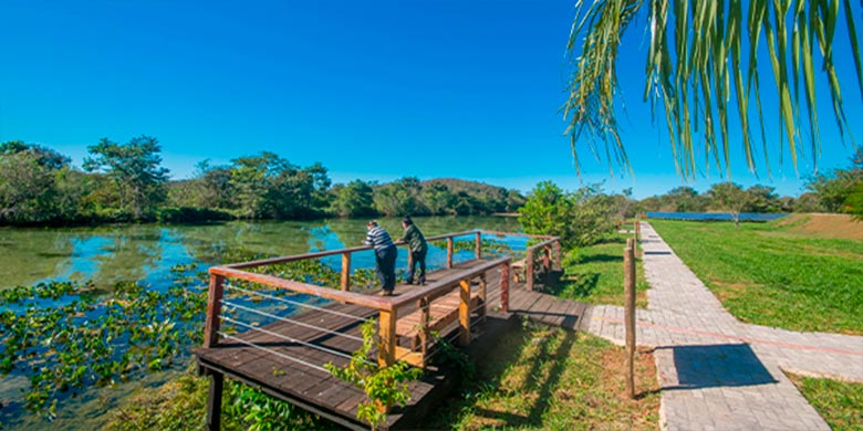 Duas pessoas em deck de contemplação para o Lago Pantanal criado em trilha ecológica dentro do espaço Nascente Azul - imersão Bonito e Pantanal