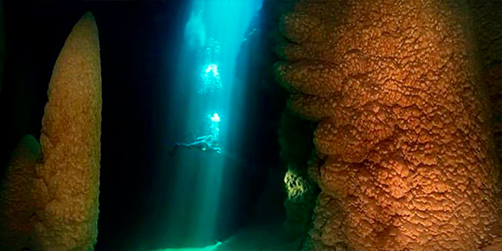 Visão panorâmica do mergulho com cilindro em meio a formações naturais em formato de cones encontradas no lago submerso do Abismo Anhumas em Bonito MS - uma das águas mais cristalinas do Brasil