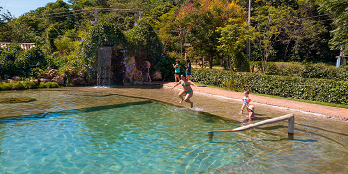 Opção de água corrente e rasa para passeios com crianças em Bonito MS - vista aérea de piscina natural e ecológica formada dentro do espaço de balneário da Nascente Azul