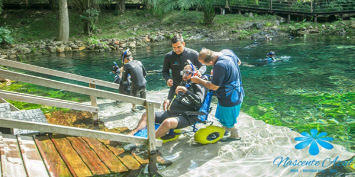 Pessoa com mobilidade reduzida usando equipamentos adaptados para flutuar e viver a emoção das aventuras aquáticas em Bonito MS